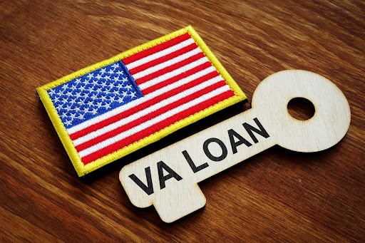 A patch of the US flag next to a wooden key with ‘VA LOAN” printed on it