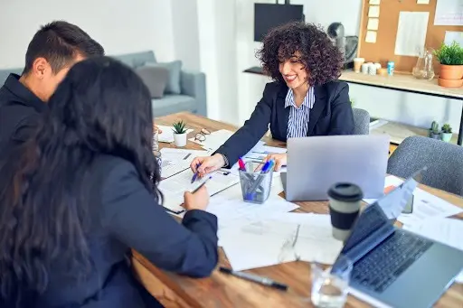 A lender sitting with a couple reviewing documents