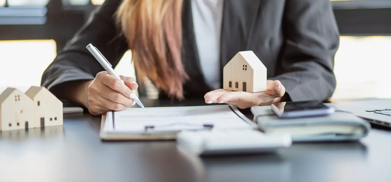 Female woman hands holding home model, small miniature white toy house. Mortgage property insurance dream moving home and real estate concept
