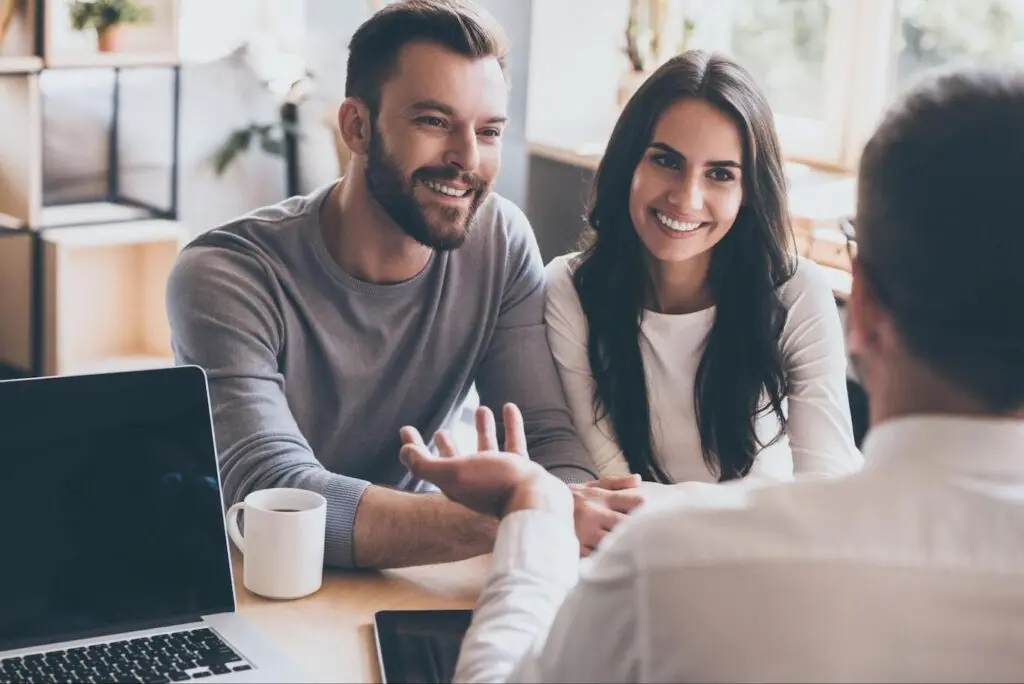 Happy couple speaking with a mortgage professional