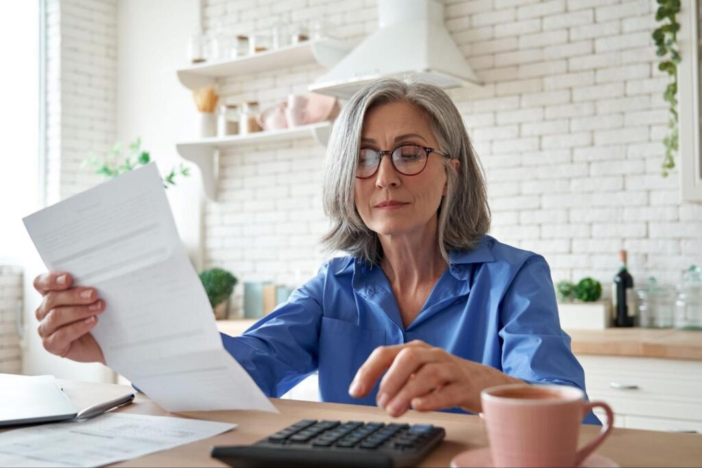 Older woman calculating APR and interest rates.
