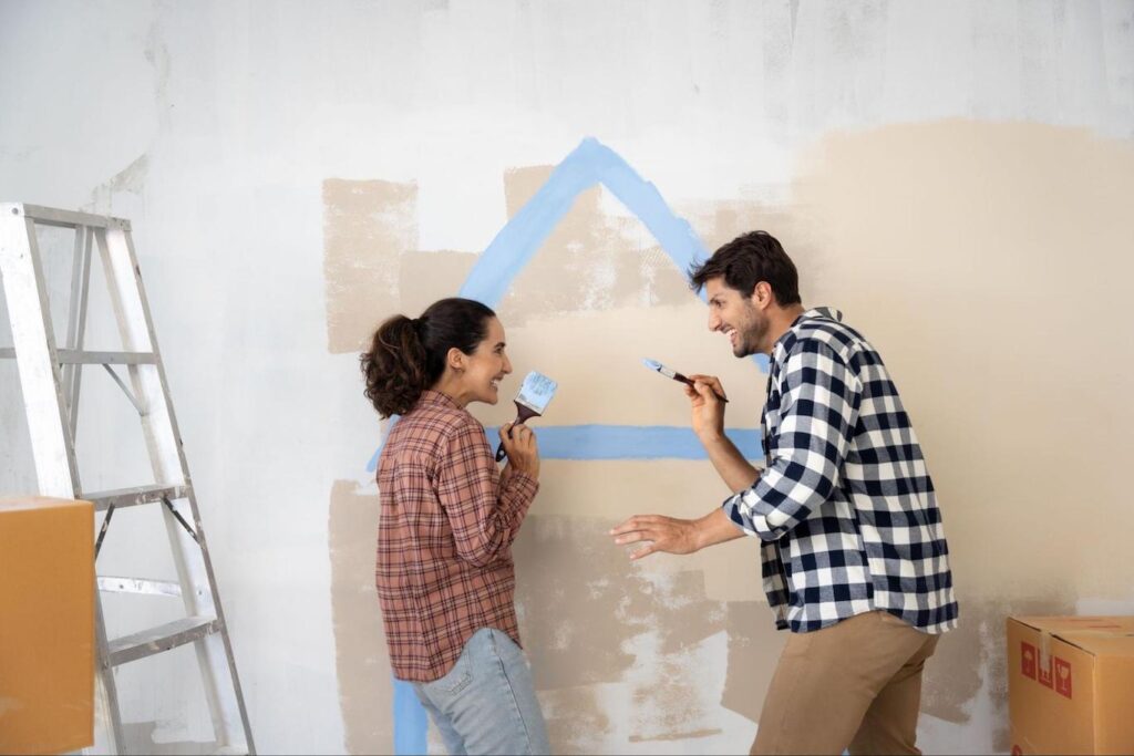 Young couple painting wall as a home improvement project.