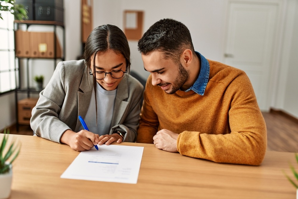 Young couple signing a contract for a home warranty.
