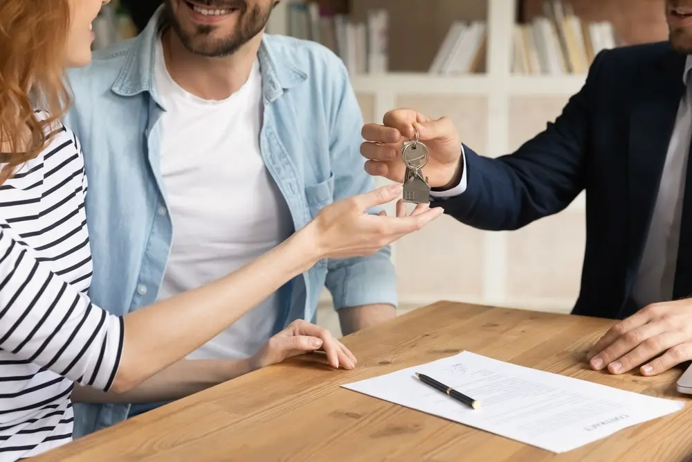 Close-up of couple receiving keys to new home
