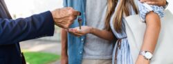 A realtor handing over the house keys to a young couple.