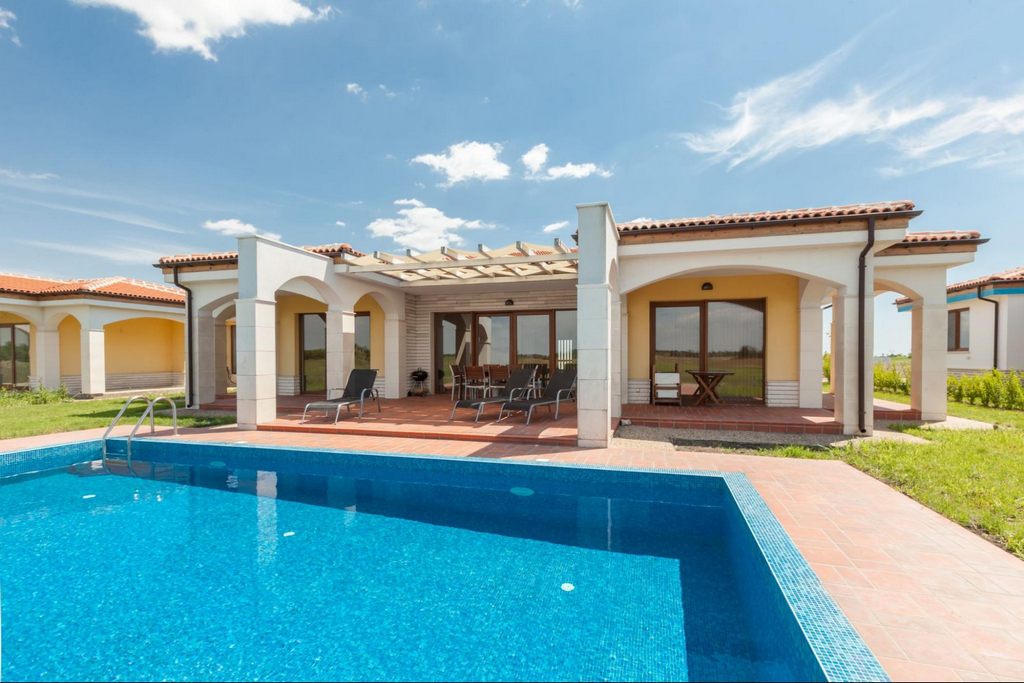 A swimming pool in the backyard of a luxury vacation home. 