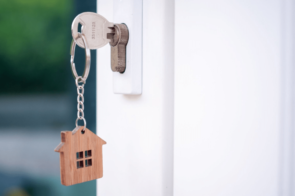 A house key with a key ring inserted into a door lock.