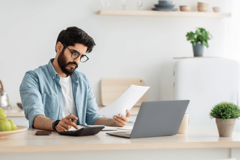 A man sitting at his table working on his taxes.