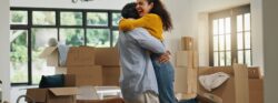 Hug, success and moving with couple in new home for property, support and mortgage approval. Real estate investment, celebration and relocation with man and woman in living room for house purchase.