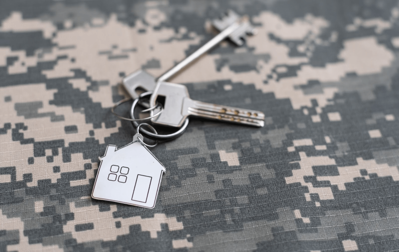 A set of new house keys on top of military camo. 
