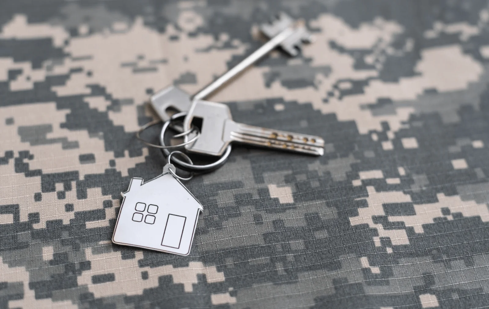 A set of new house keys on top of military camo.