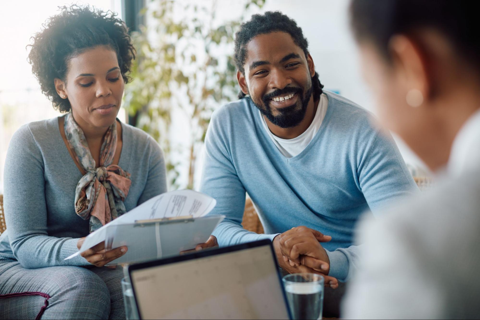 A couple reviewing documents and speaking with their mortgage lender.