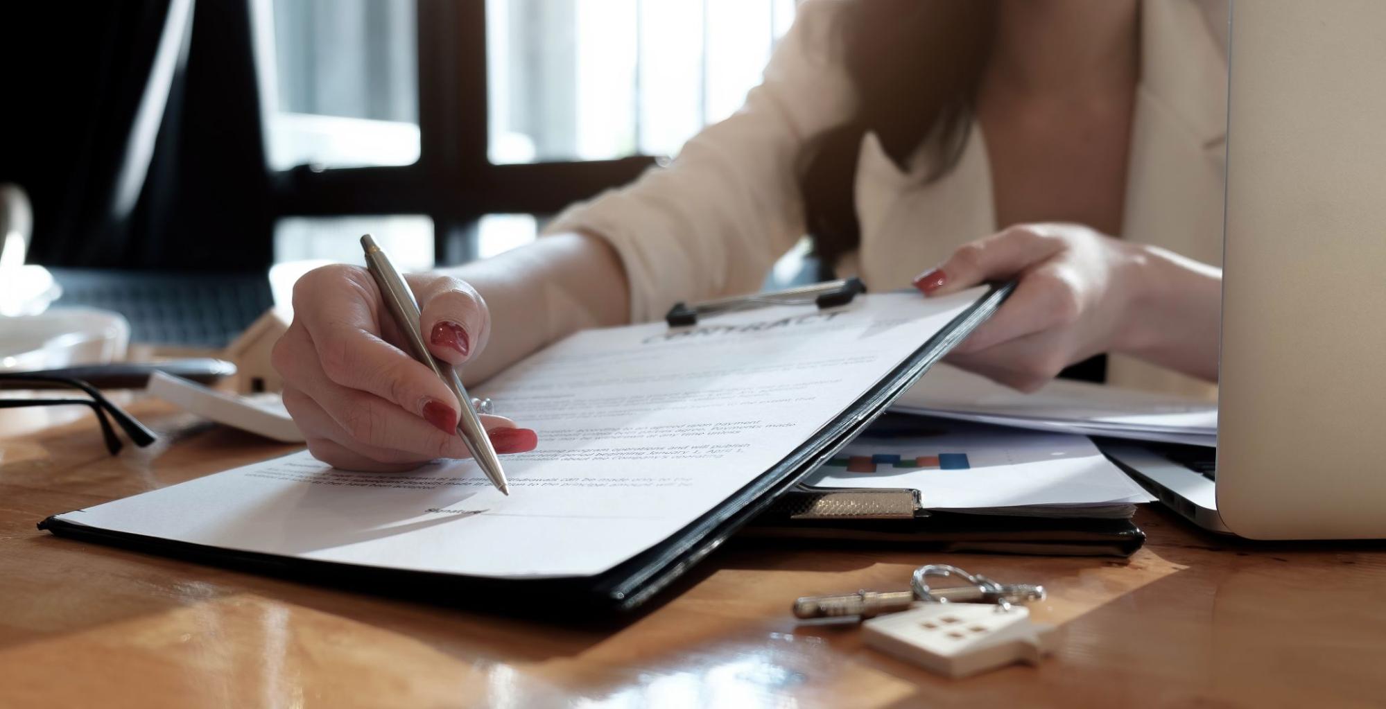 A woman pointing a pen towards a mortgage contract. 