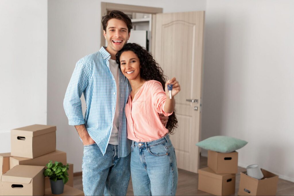 A smiling couple holding up the keys to their new home.