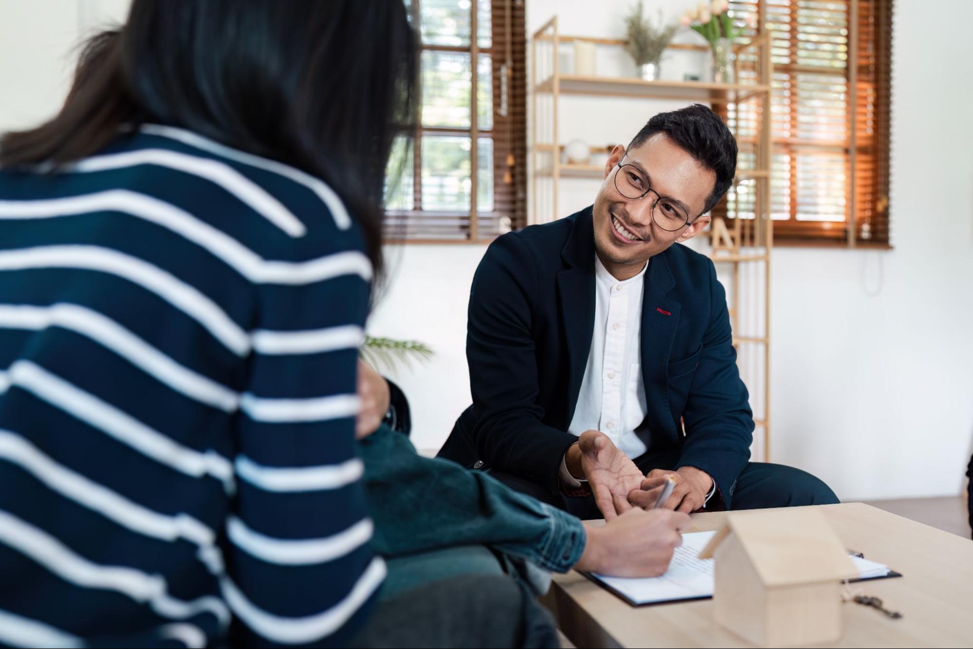 A mortgage professional speaking with a young couple. 