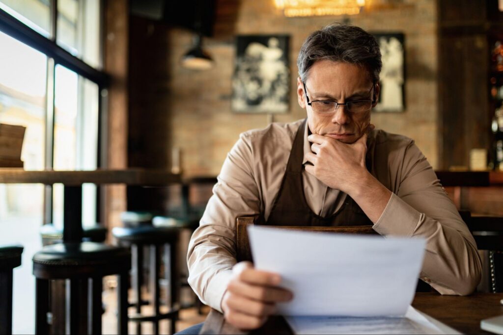 A middle-aged male landlord reviews documents.
