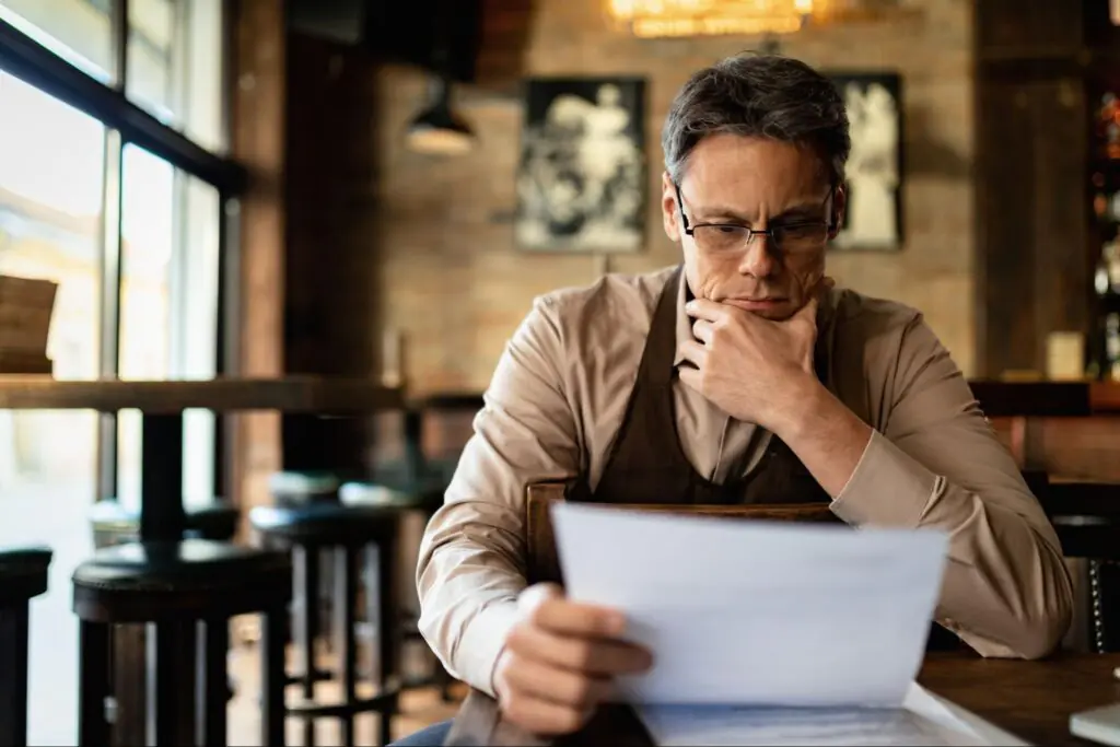 A middle-aged male landlord reviews documents.