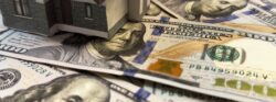 House,,Money,And,Wallet,On,White.,Buying,Real,Estate,And Model house sitting on U.S. dollar bills representing real estate financing and mortgage investment