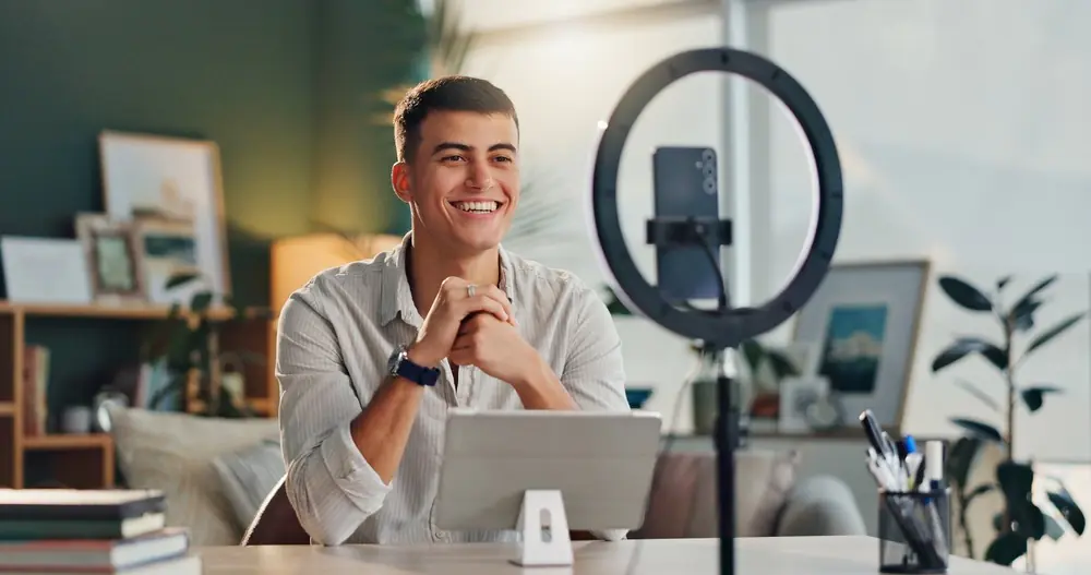 Content creator recording a video with a smartphone and ring light at home